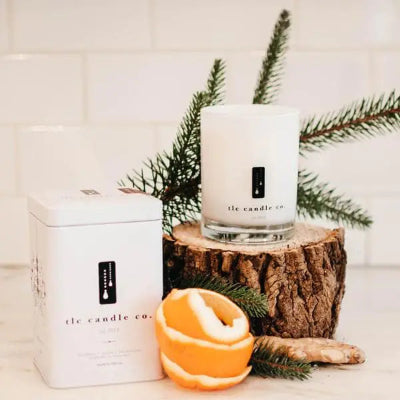 Candle and container with decorative elements on a white surface
